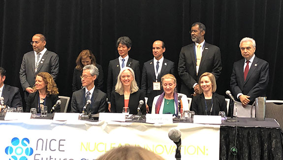 Photo of a diverse group of participants – 5 women and 6 men, half seated and half standing – at the Clean Energy Ministerial 10 meeting.