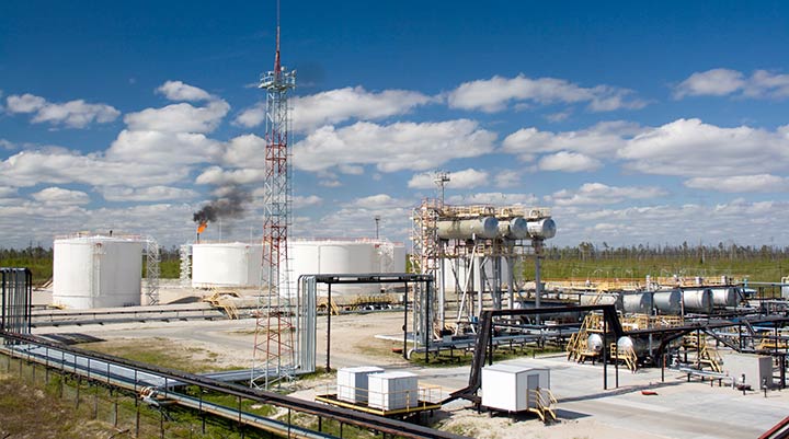 Photo of an oil and gas refinery with a gas flare shown.