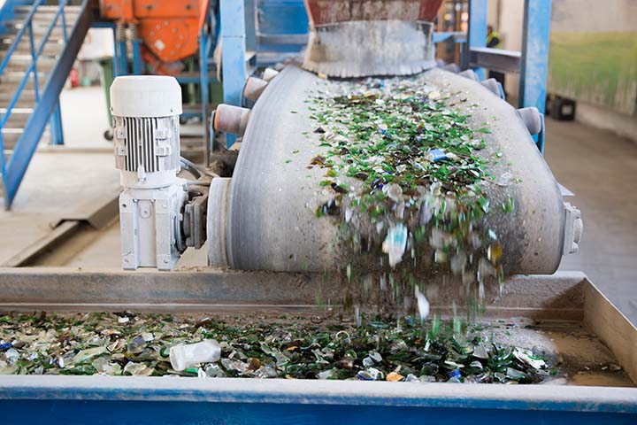 Photo of glass materials moving along a conveyor belt at a glass recycling facility. Solar panels are often recycled the same way as glass, but they require specialized processes to recover the valuable materials.