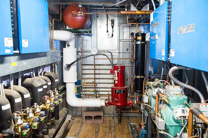 Photo of a refrigeration system that has parallel pipes and compressors.