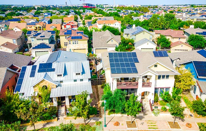 Photo of a residential community with homes of various sizes and solar panels on the roofs.